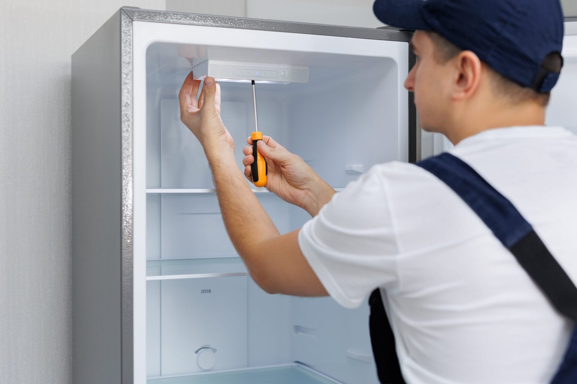 man-in-a-uniform-repairs-the-light-in-the-refriger-2025-01-10-20-40-34-utc-min